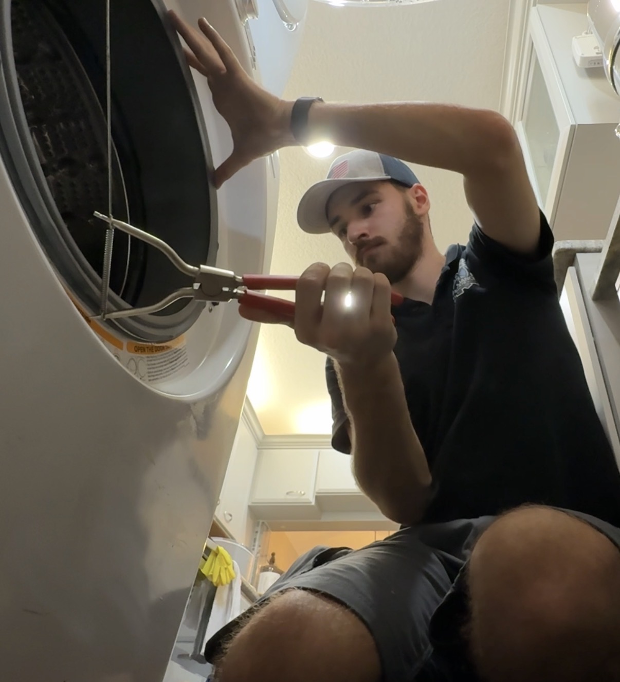 Technician working on washer door seal with pliers